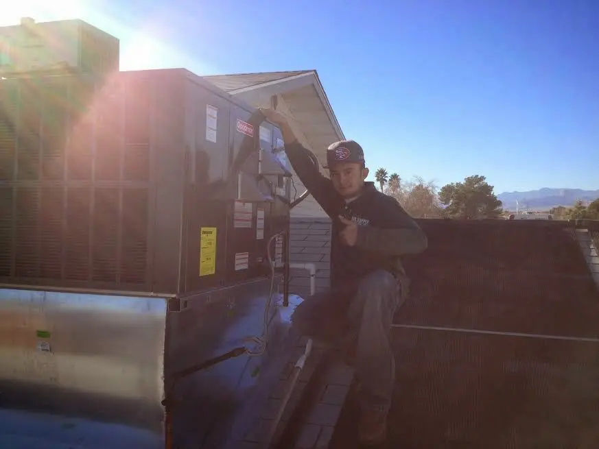 HVAC technician performing AC Tune-Up on a rooftop unit in Vestal